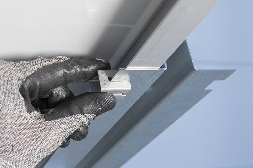  A hand is installing the product on the solar installation