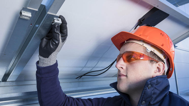 Fixations de panneaux solaires Technicien fixant une fixation de panneau solaire